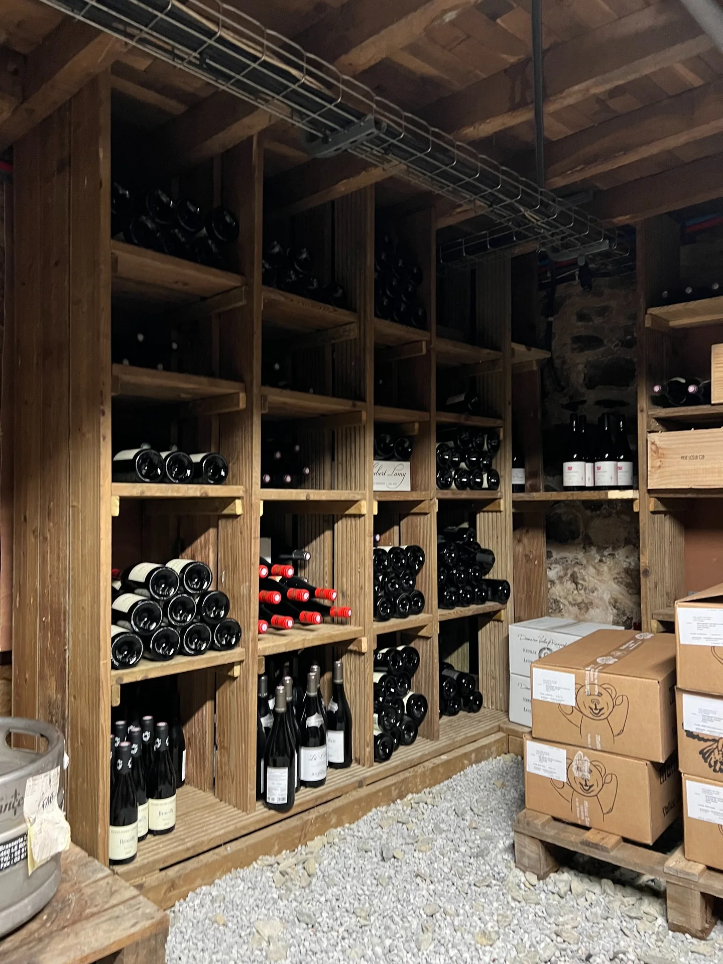 Bouteilles de vin rangées dans les casiers en bois de la cave de Cocorico